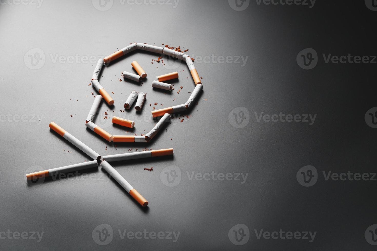 Skull from cigarettes on a black background. The concept of smoking kills. Toward the concept of smoking as a deadly habit, nicotine poisons, cancer from smoking, illness, quit smoking. photo