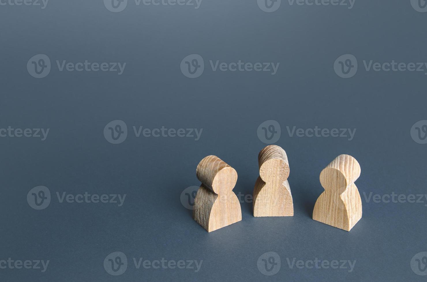 Three human figurines. Communication and discussion. Friendly relations. A meeting. Assistance, cooperation and collaboration. photo