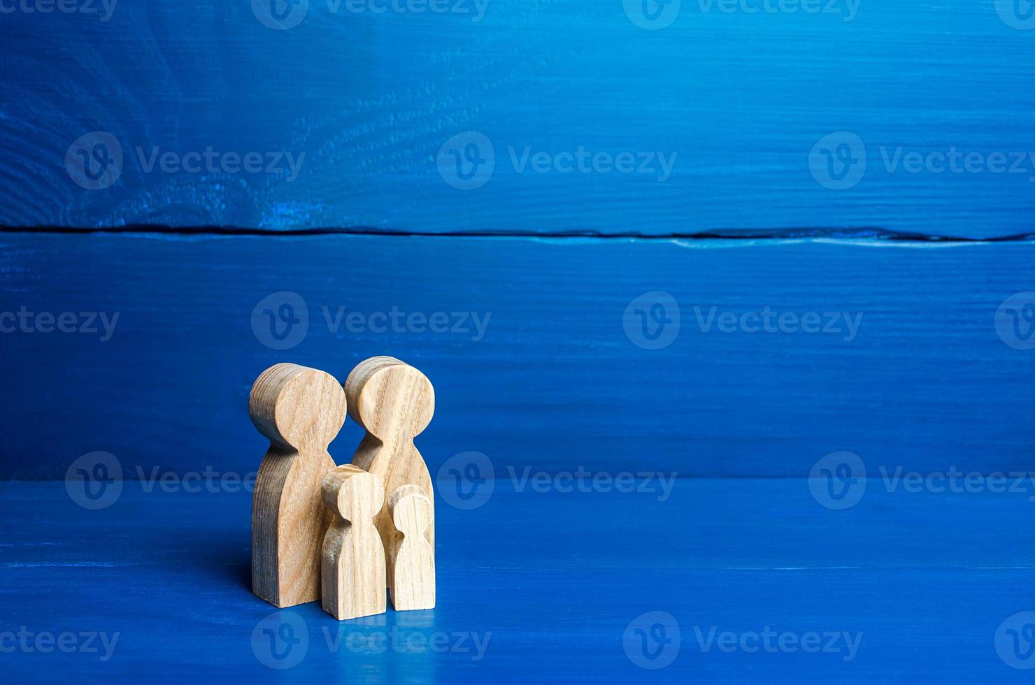 Family figures of parents and kids on a blue background. Family values and health. Adoption and custody of children. Social support, demography, sociology. Upbringing and education. Together concept photo