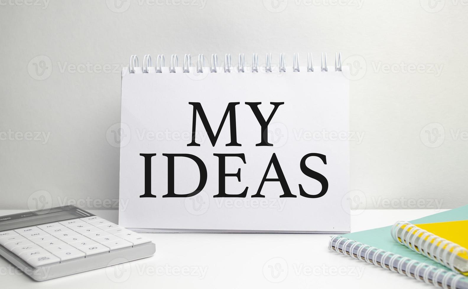 redactar mis ideas en un cuaderno blanco con calculadora foto