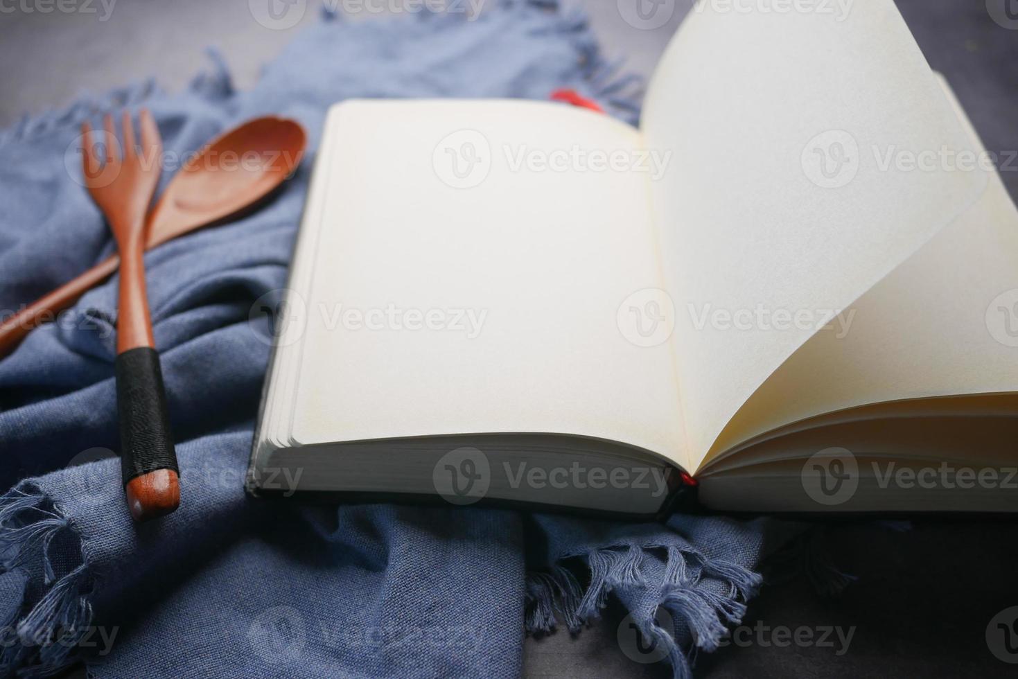 open notepad and wooden spoon on table cloth photo