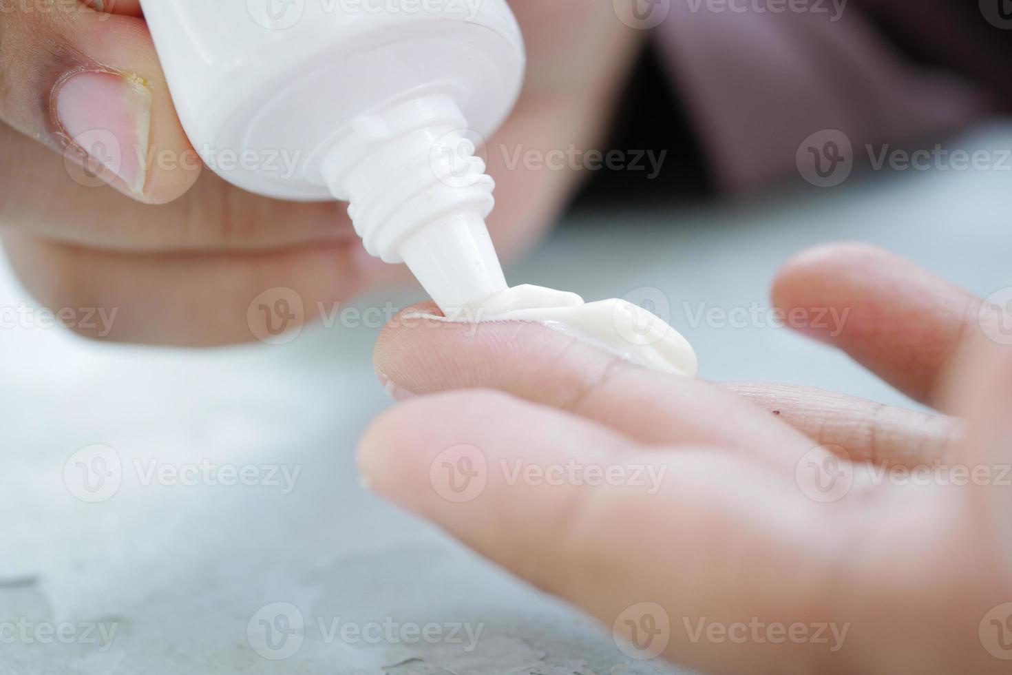 close up of hand using sunscreen cream photo