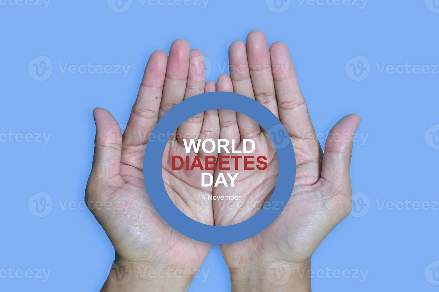 Top view inscription world diabetes day and hand gesture with red blood drop in man hands isolated on a blue background. World diabetes day, 14 november. Copy space., Health Awareness photo