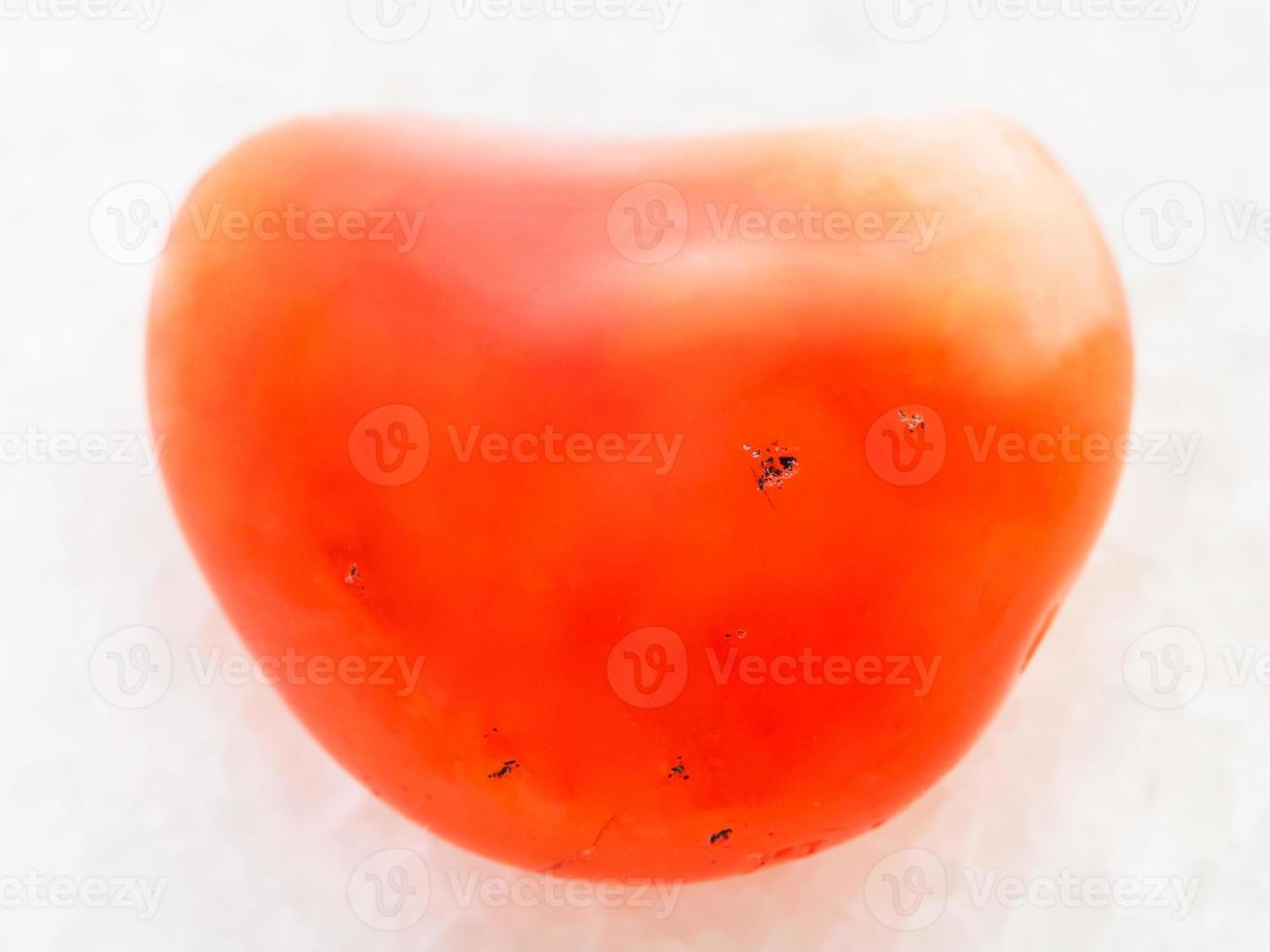 tumbled carnelian gem on white marble photo