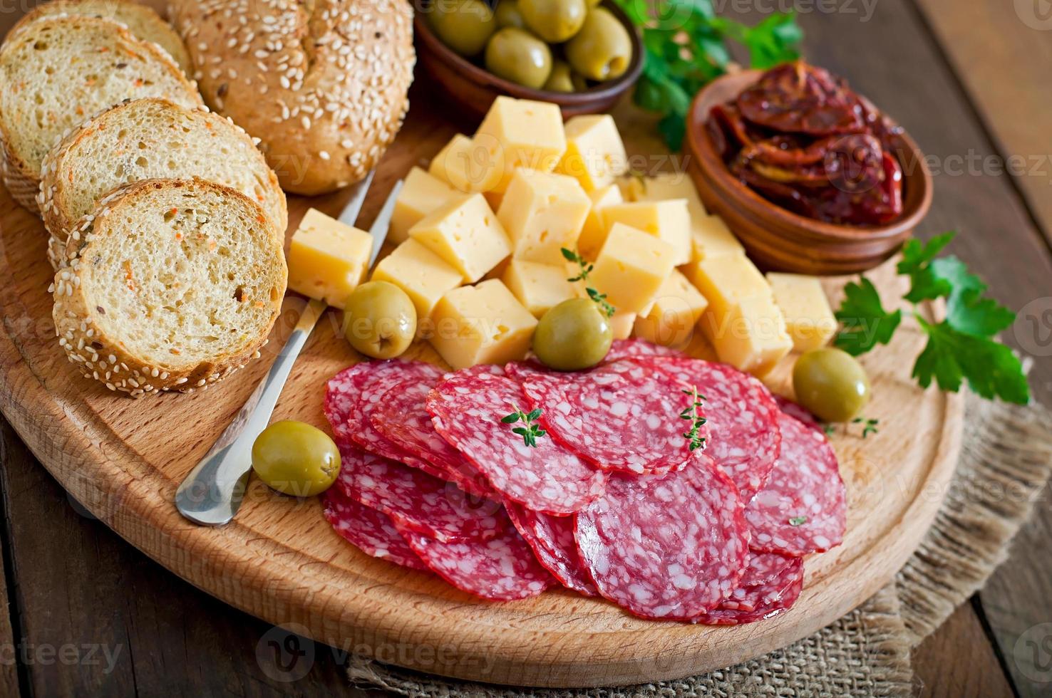 fuente de catering antipasto con salami y queso sobre un fondo de madera foto