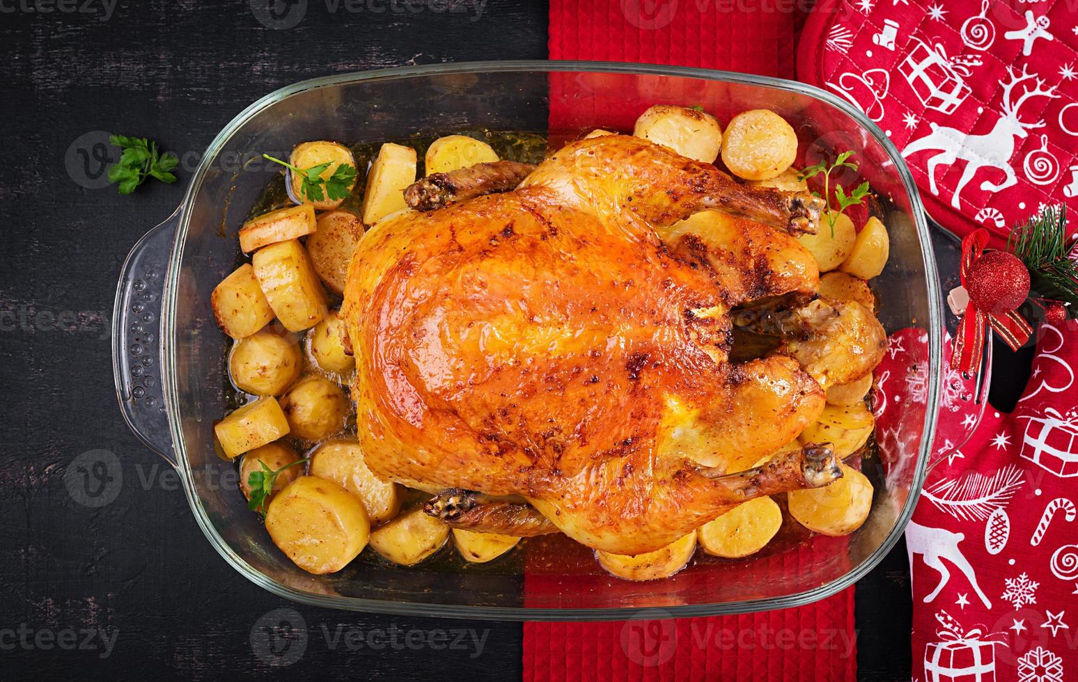 Baked turkey or chicken. The Christmas table is served with a turkey, decorated with bright tinsel. Fried chicken, table. Christmas dinner.  Top view, above photo