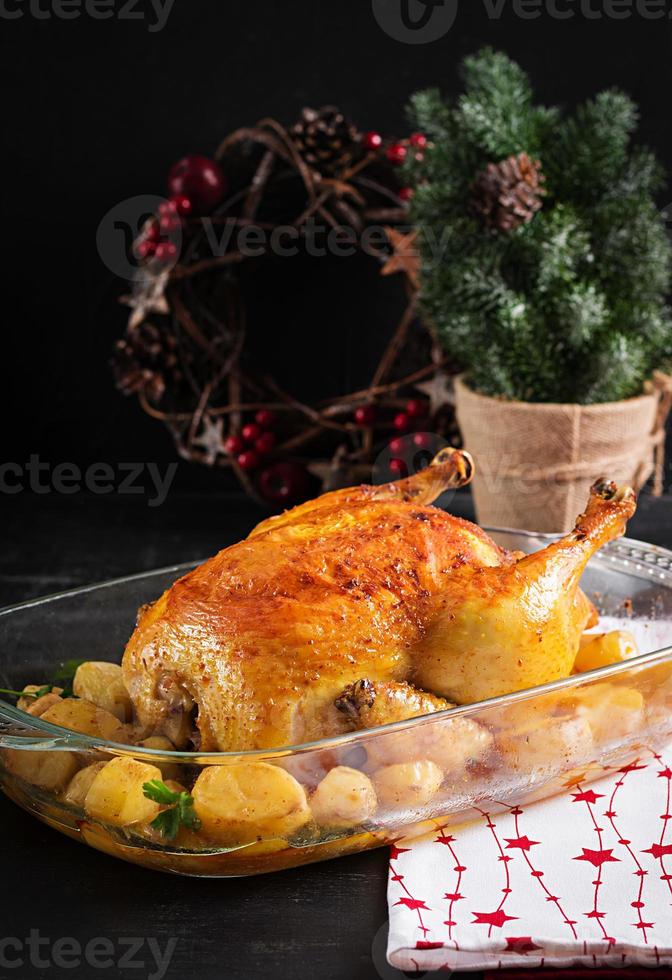 Baked turkey or chicken. The Christmas table is served with a turkey, decorated with bright tinsel. Fried chicken, table. Christmas dinner. photo