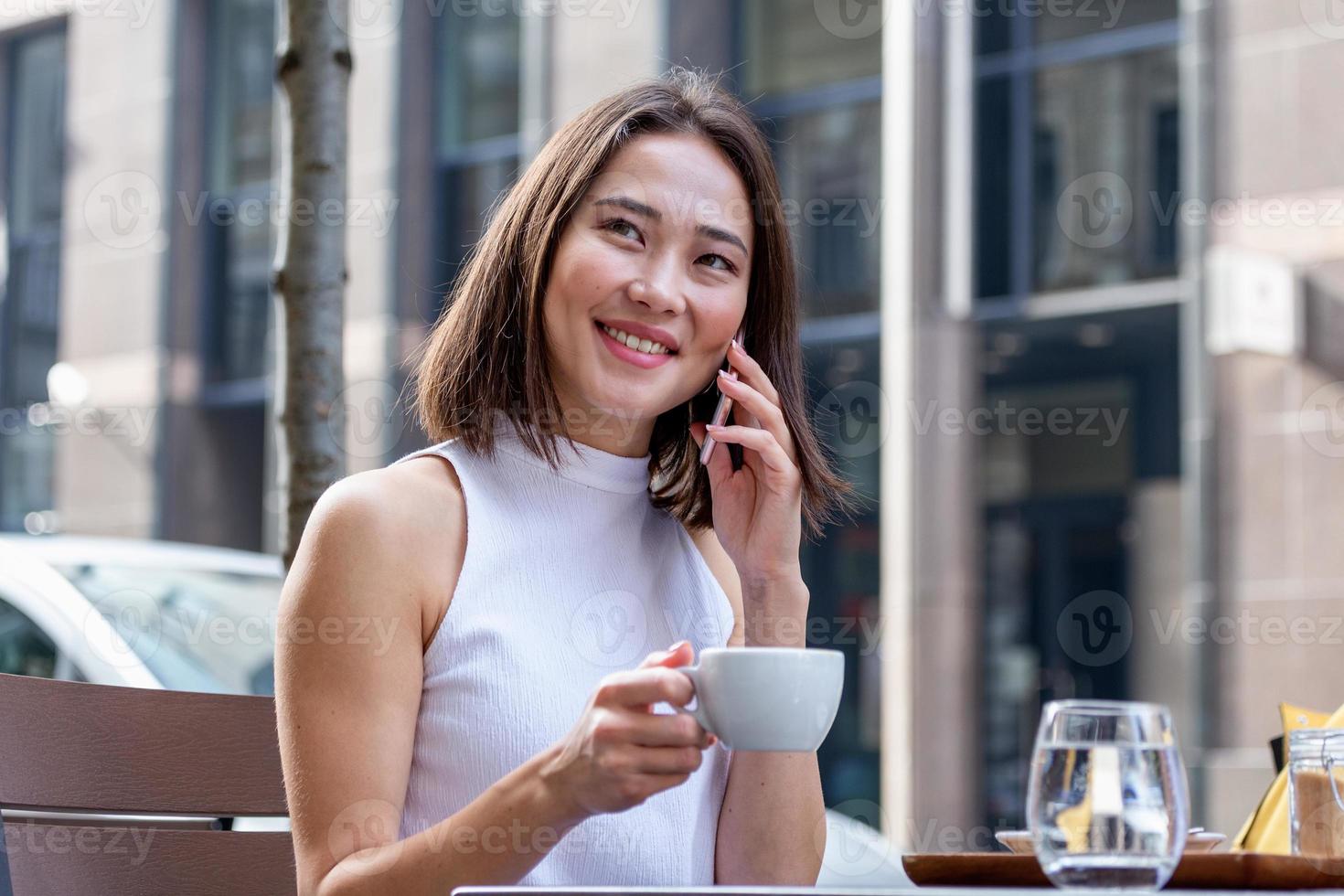 mujer asiática que trabaja en una computadora portátil en un café. mujer joven que trabaja en una computadora portátil. hermosa joven que trabaja con una laptop de una cafetería. mujer atractiva sentada en un café con una laptop foto