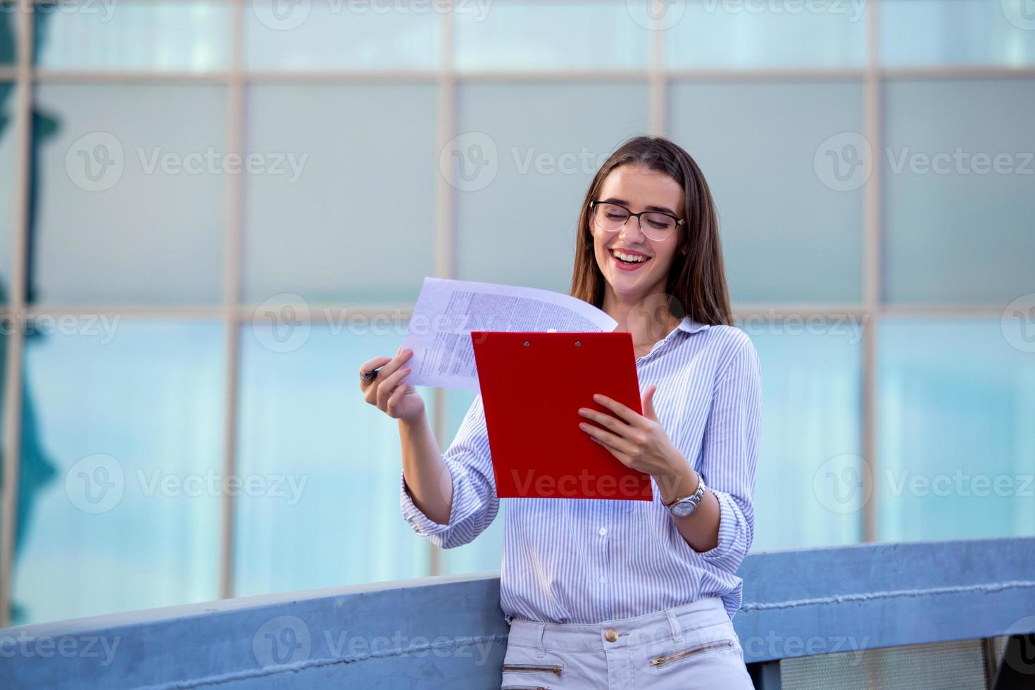 Executive business woman with clipboard against the urban background photo