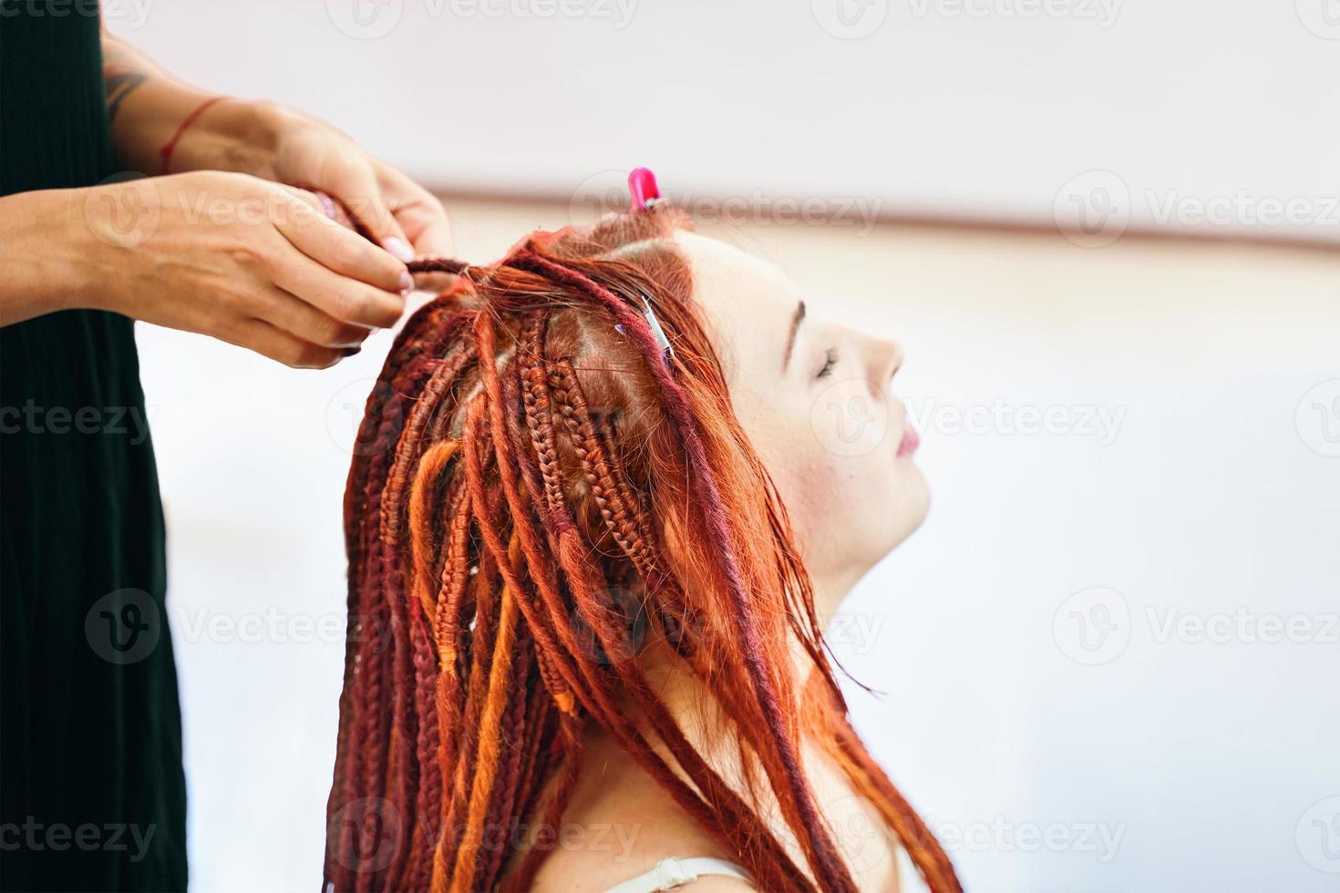 proceso de trenzado de trenzas en la cabeza en salón de belleza. foto