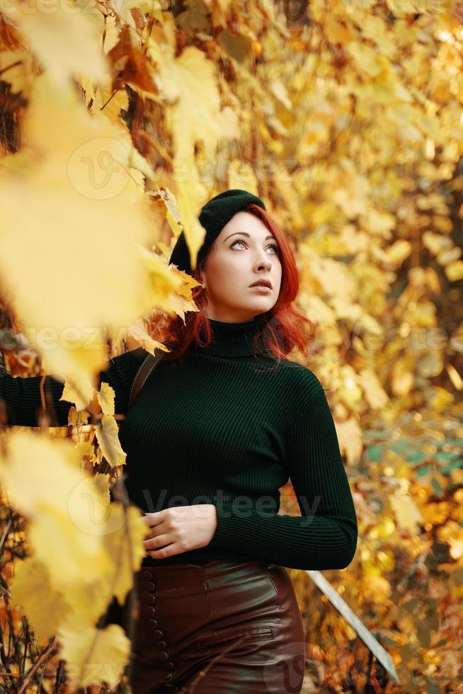 Stylish red-haired woman in autumn park. photo