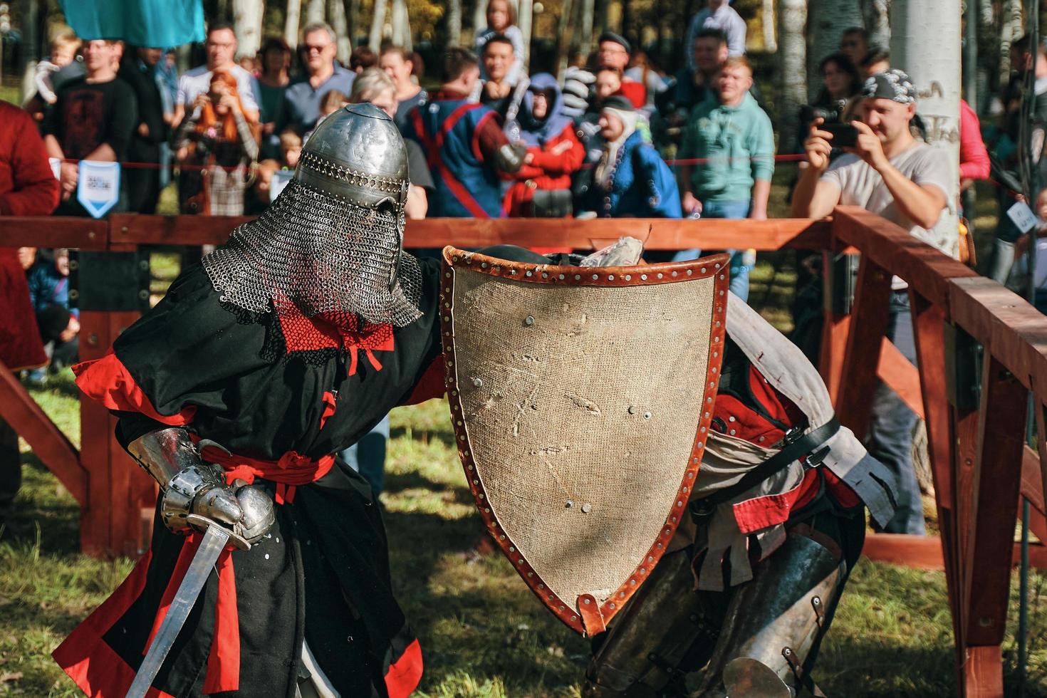 batalla de caballeros en armadura y cascos en espadas. foto