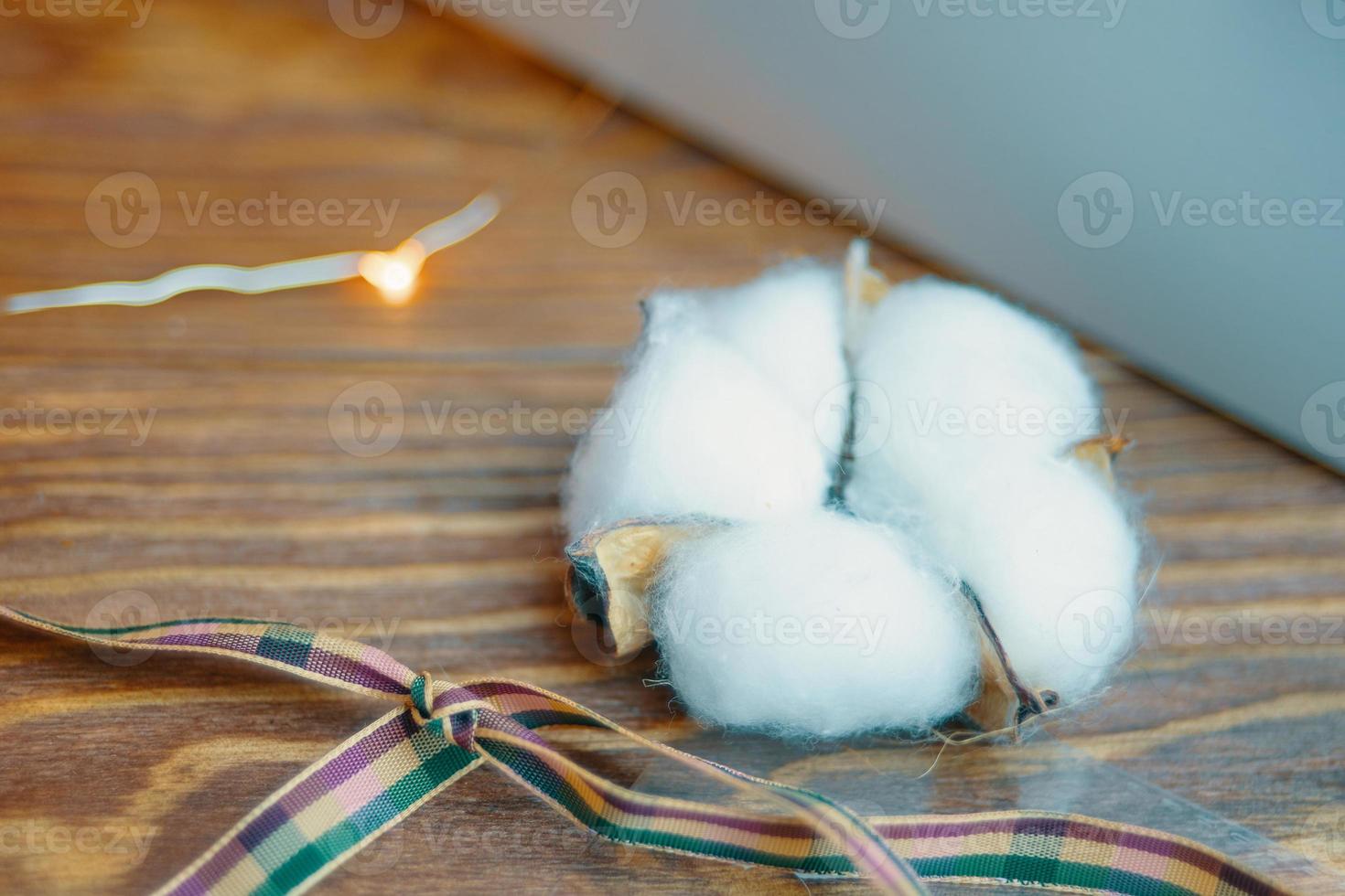 Cotton and ribbon on wooden table. photo