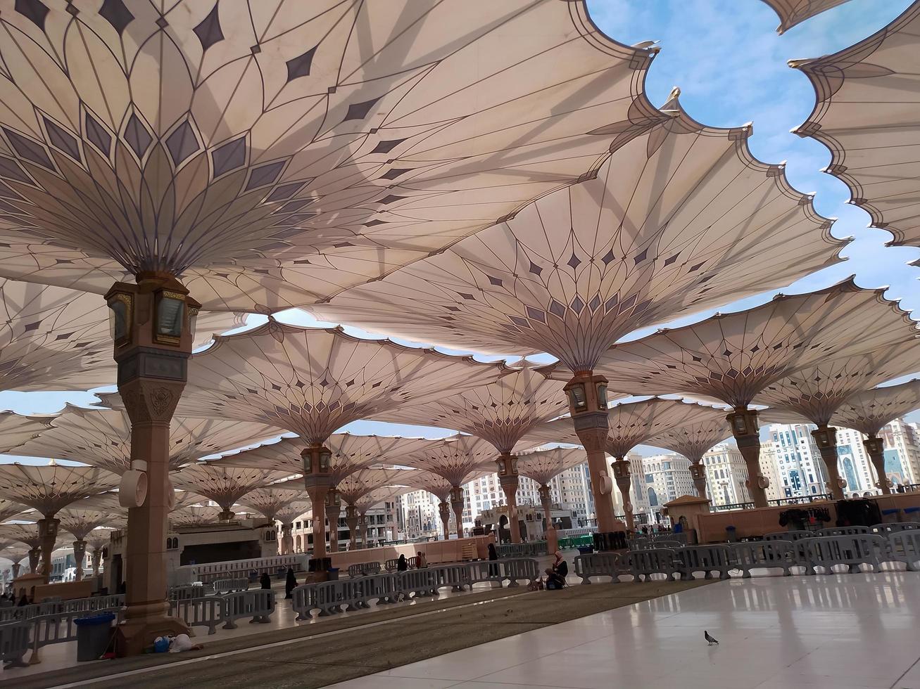 Medina, Saudi Arabia, 2022 - Umbrella construction on the square of Al-Masjid An-Nabawi or Prophet Muhammed Mosque are protecting people from sun at daytime and work as lights at night photo