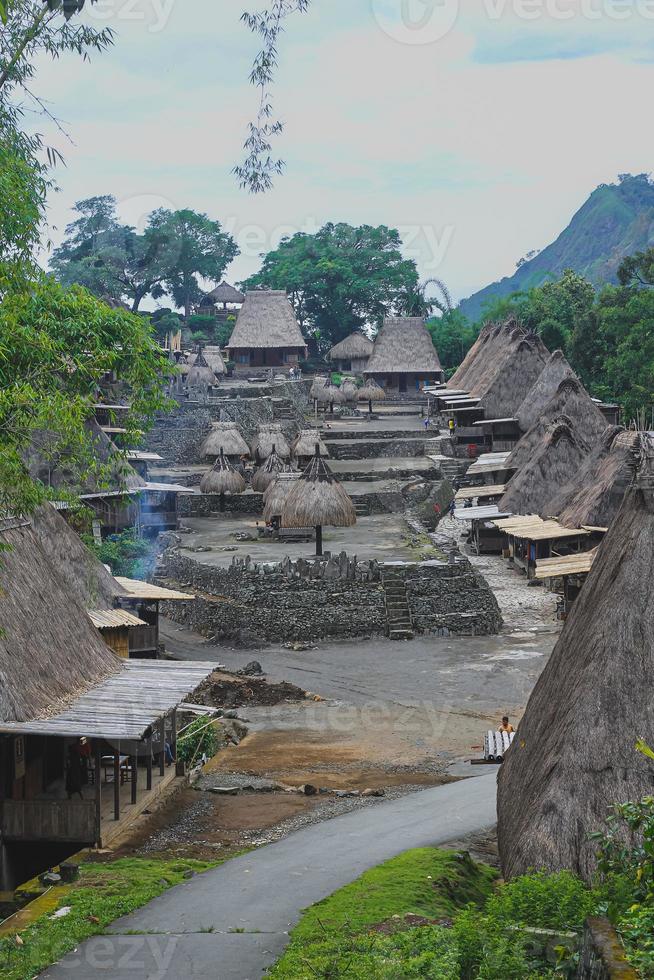 Bena a traditional village with grass huts of the Ngas people in Flores near Bajawa, Indonesia. Many small houses are made of natural parts like wood and straw. Giant volcano in the back photo