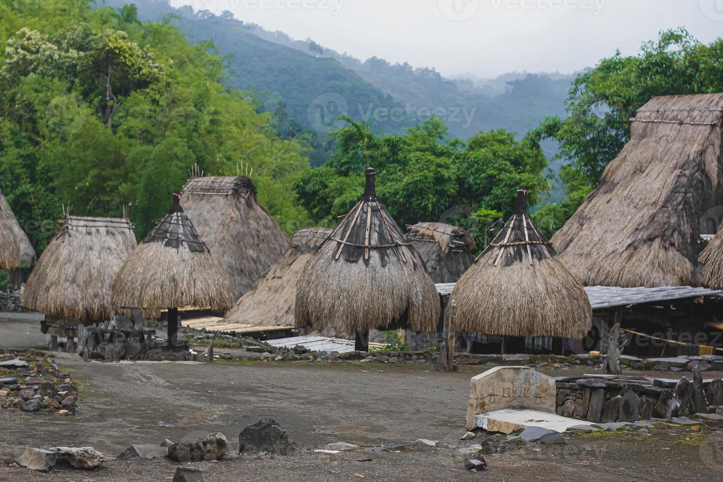 Bena a traditional village with grass huts of the Ngas people in Flores near Bajawa, Indonesia. Many small houses are made of natural parts like wood and straw. Giant volcano in the back photo