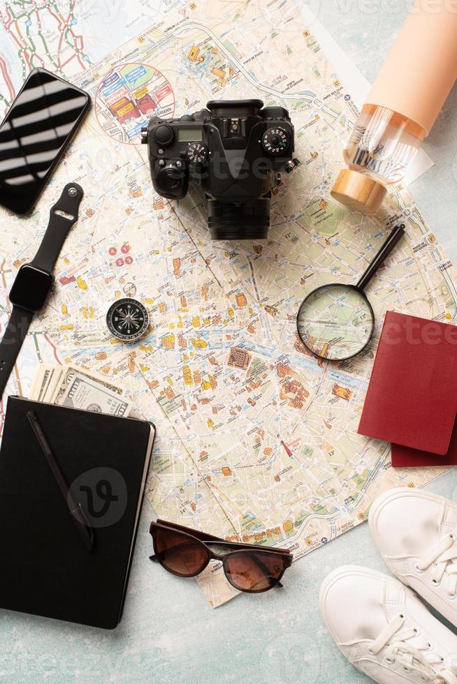 Flat lay traveler accessories on map, camera, glasses, digital devices photo