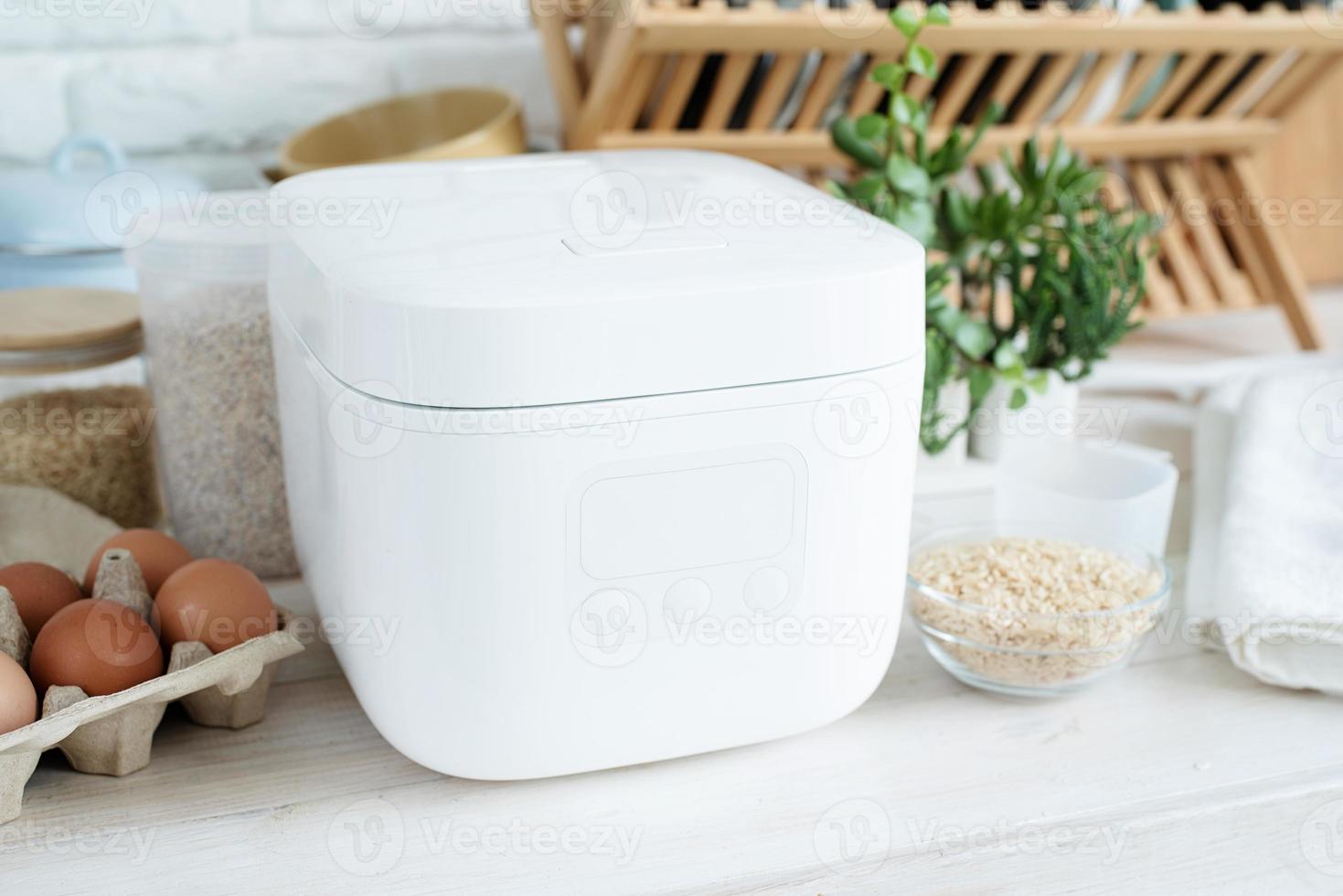 Electric rice cooker on wooden counter-top in the kitchen photo