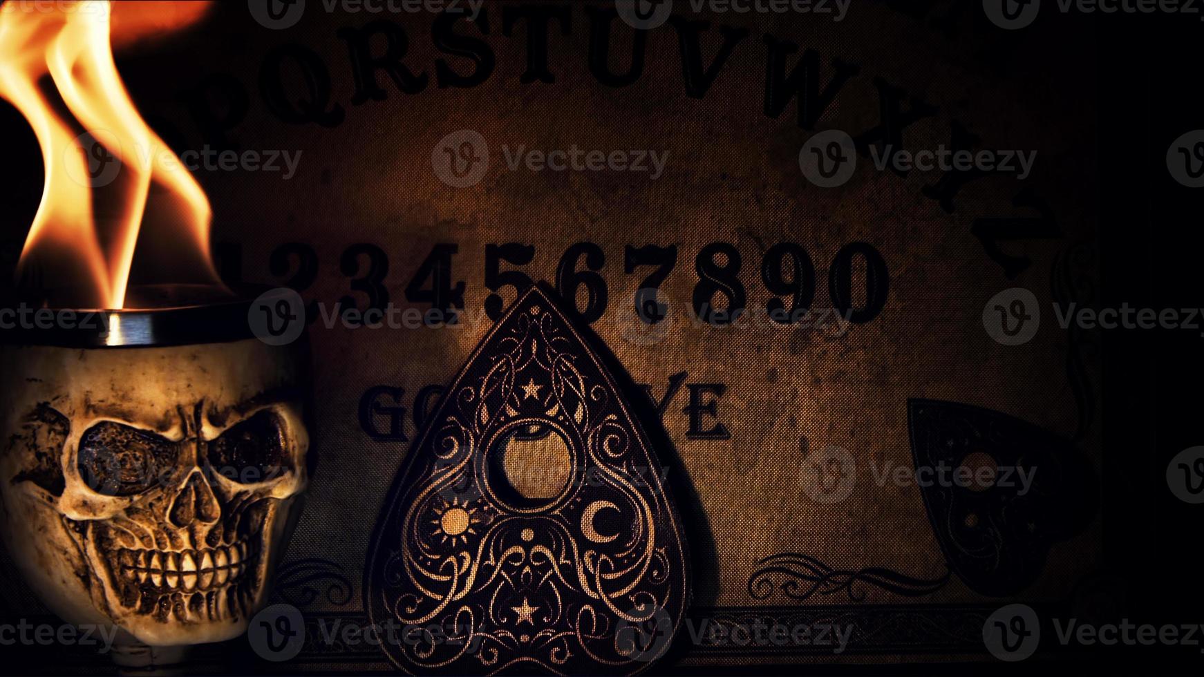 tablero de brujas ouija y cabeza de calavera en llamas foto