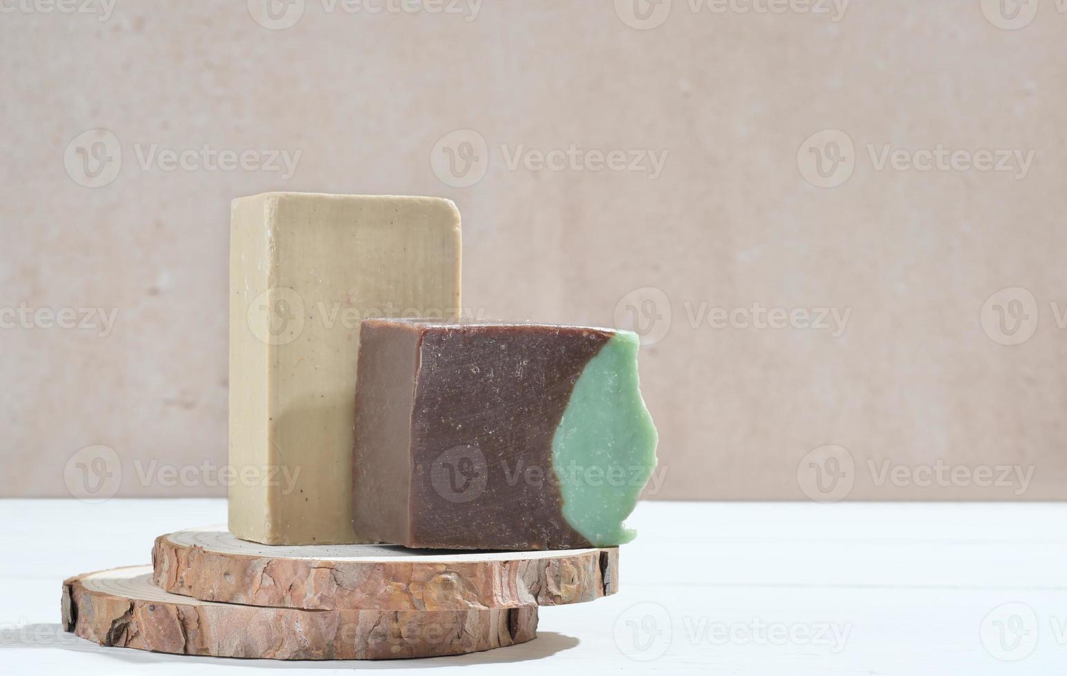 natural craft hand made soap bars on wooden podium, copy space. brown and baige solid hand soap made of organic ingredients. photo
