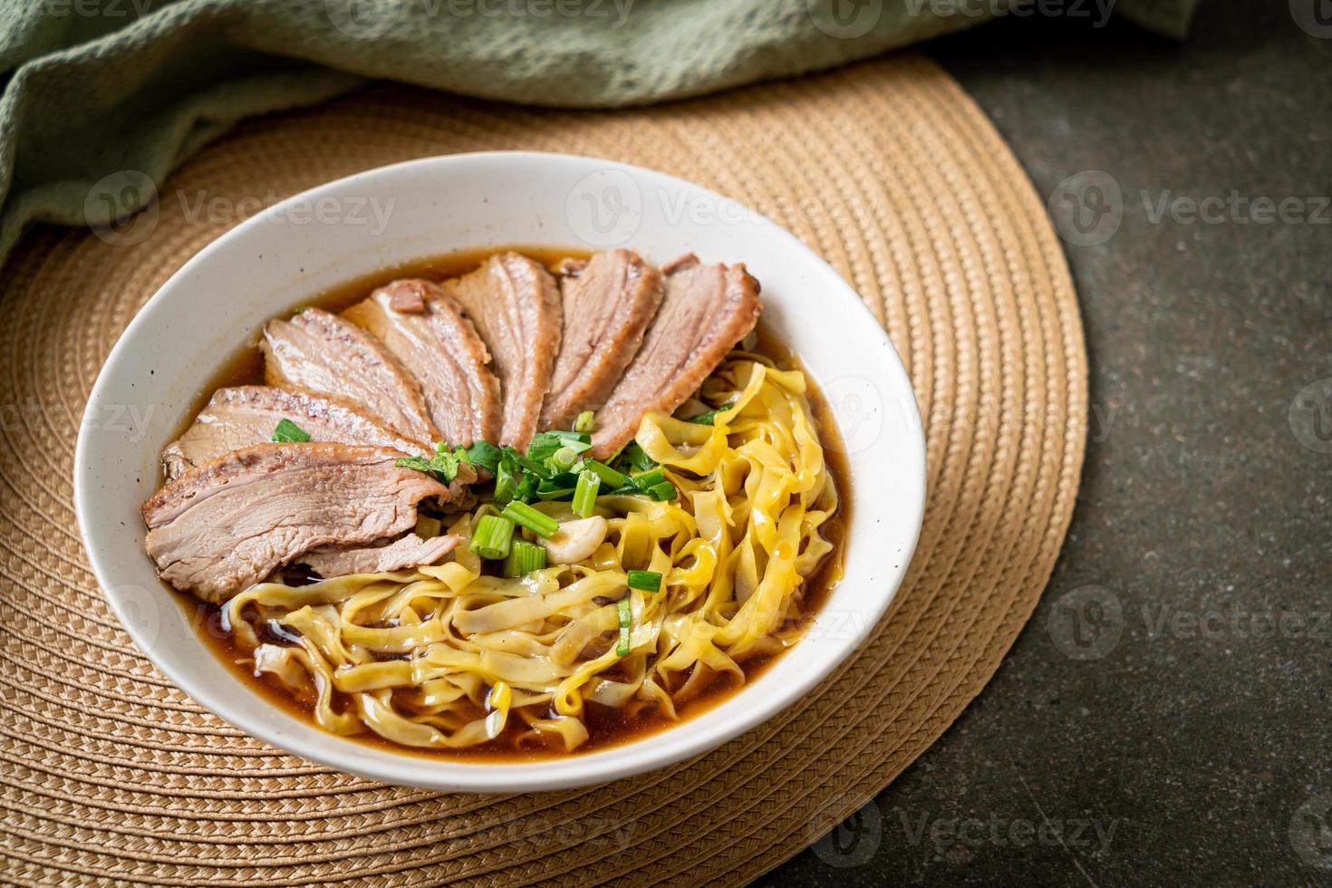 tallarines de huevo con pato guisado en sopa marrón foto