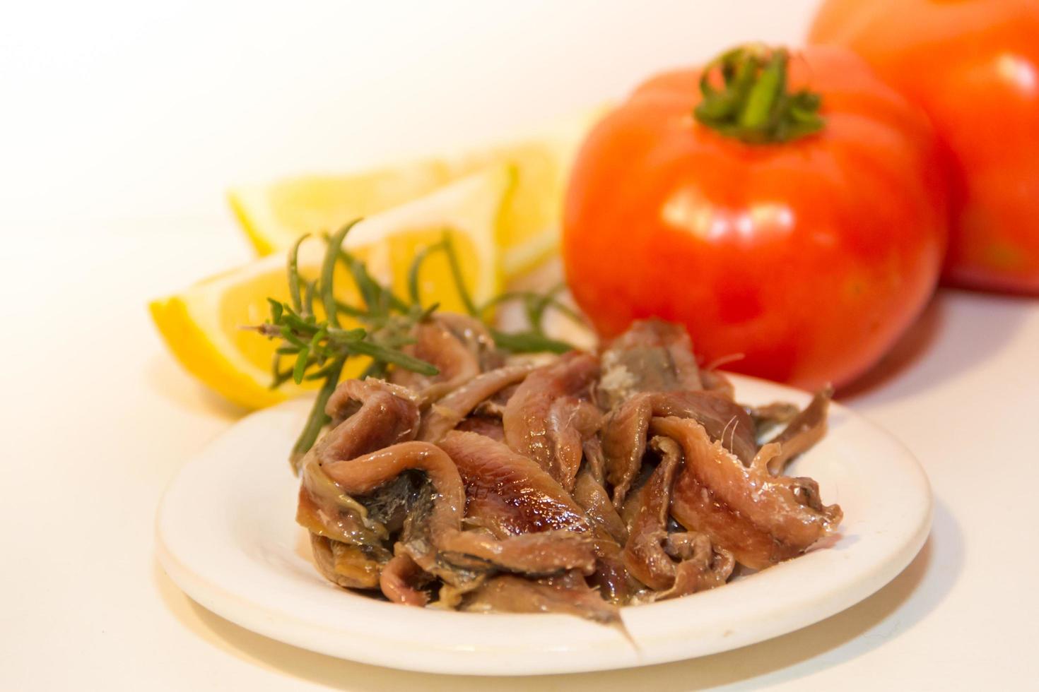 pickled anchovies with rosemary lemon vinegar and tomatoes photo