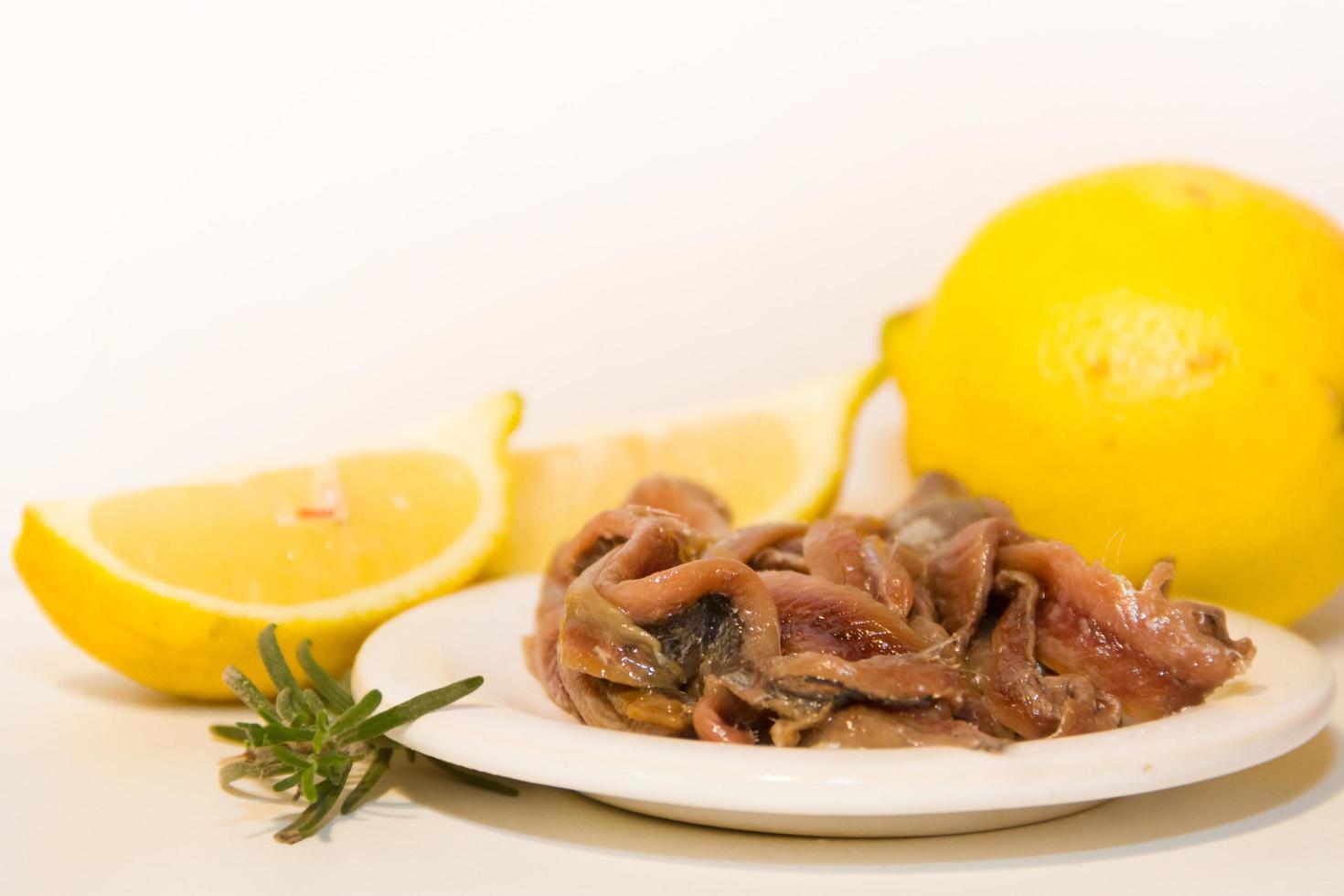 anchoas en escabeche con vinagre de limón romero y tomates foto