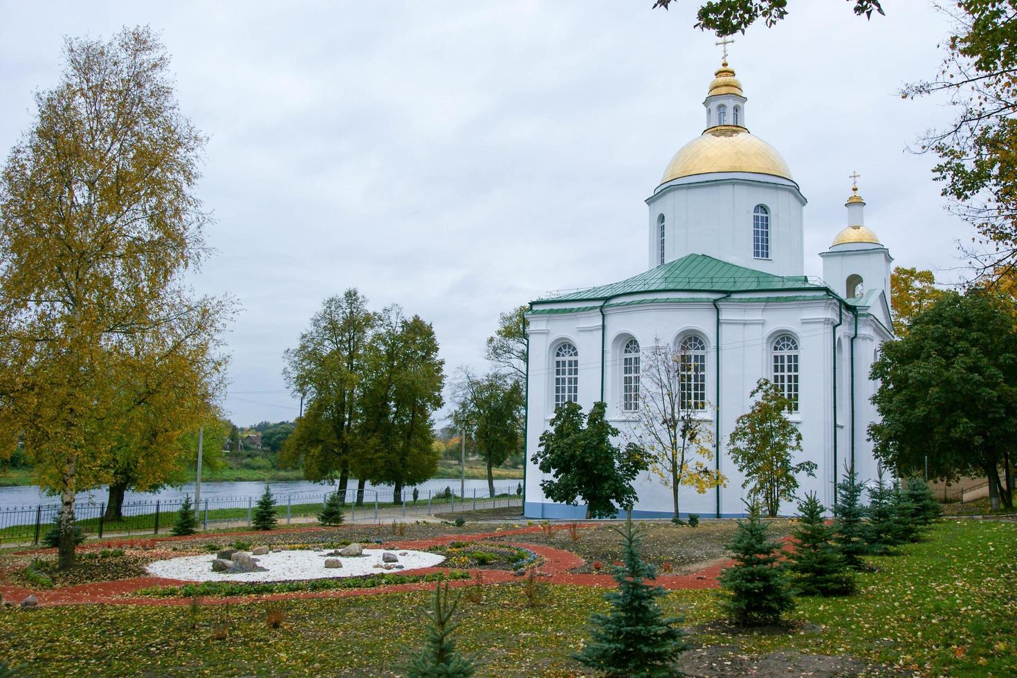 A large white stone church with a golden dome and a bell in eastern Europe is a Christian orthodox for the prayers of God photo