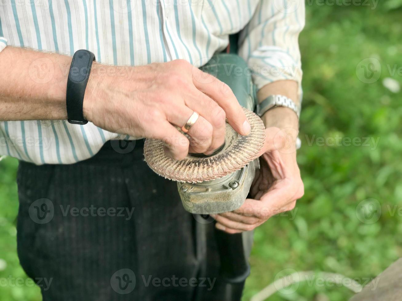 A man holds in his hand a disk of a circle used for a grinding machine for grinding and polishing surfaces from various materials wood, metal, plastic, stone photo