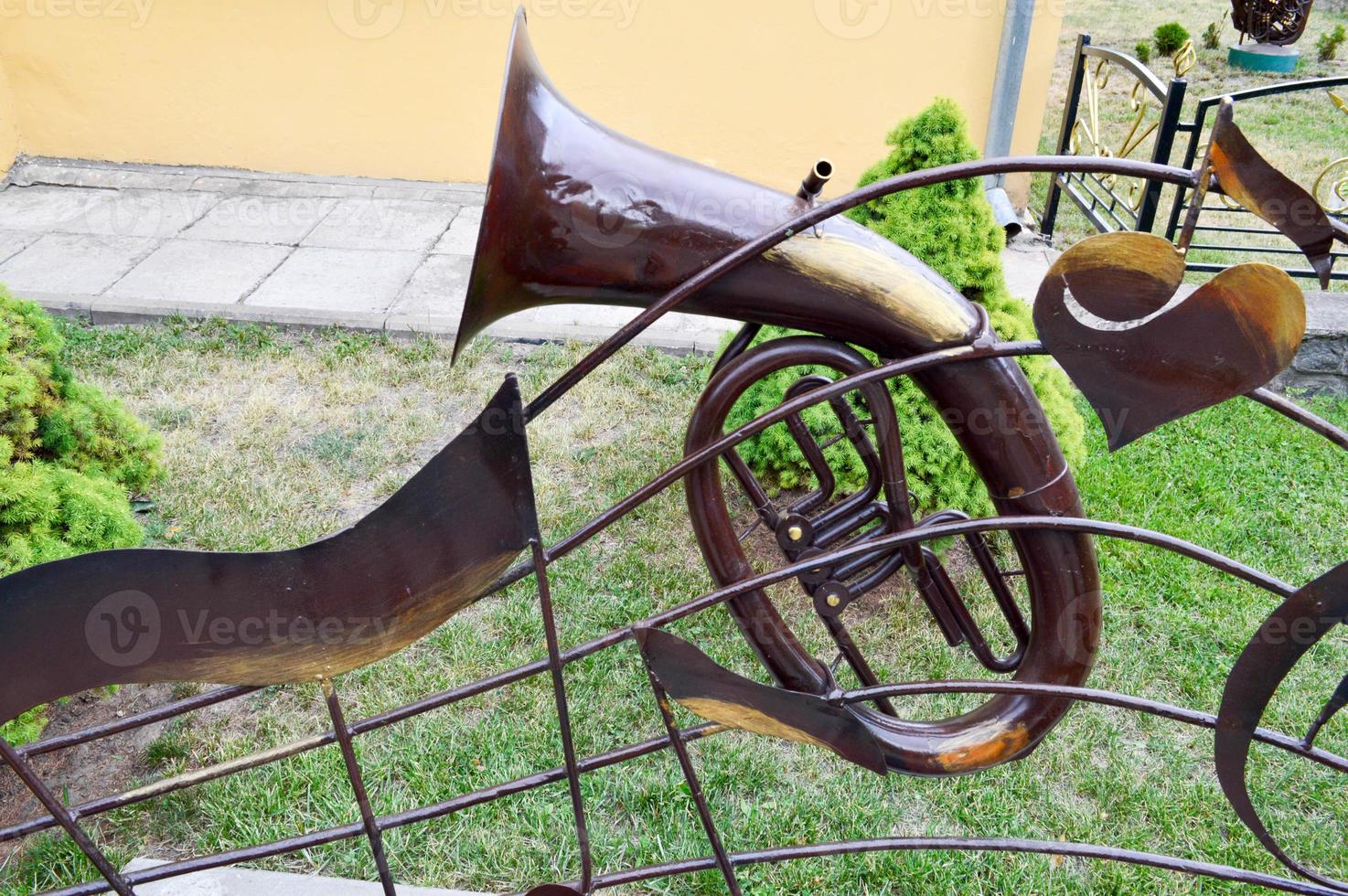 Iron brown musical trumpet, a pipe for playing music on a background of green grass photo