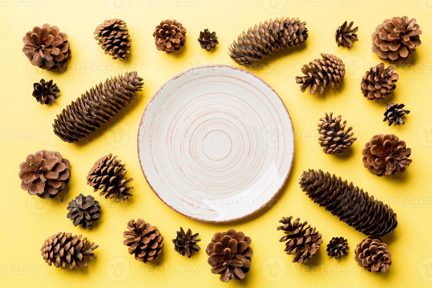Top view of festive plate with pine cones on colorful background. New Year dinner concept photo