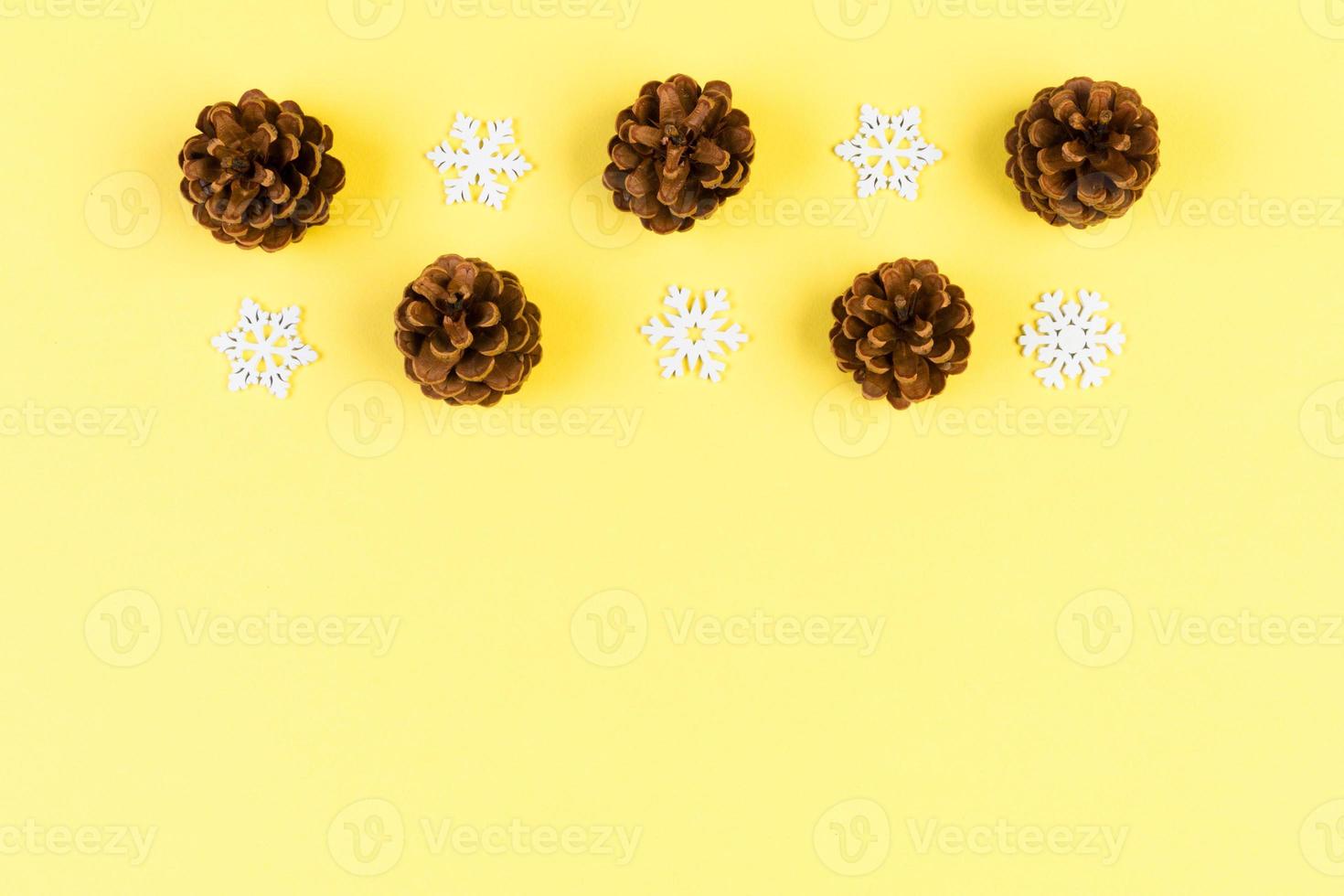Top view of holiday composition made of pine cones and white snowflakes on colorful background. Winter time and Christmas concept with copy space photo