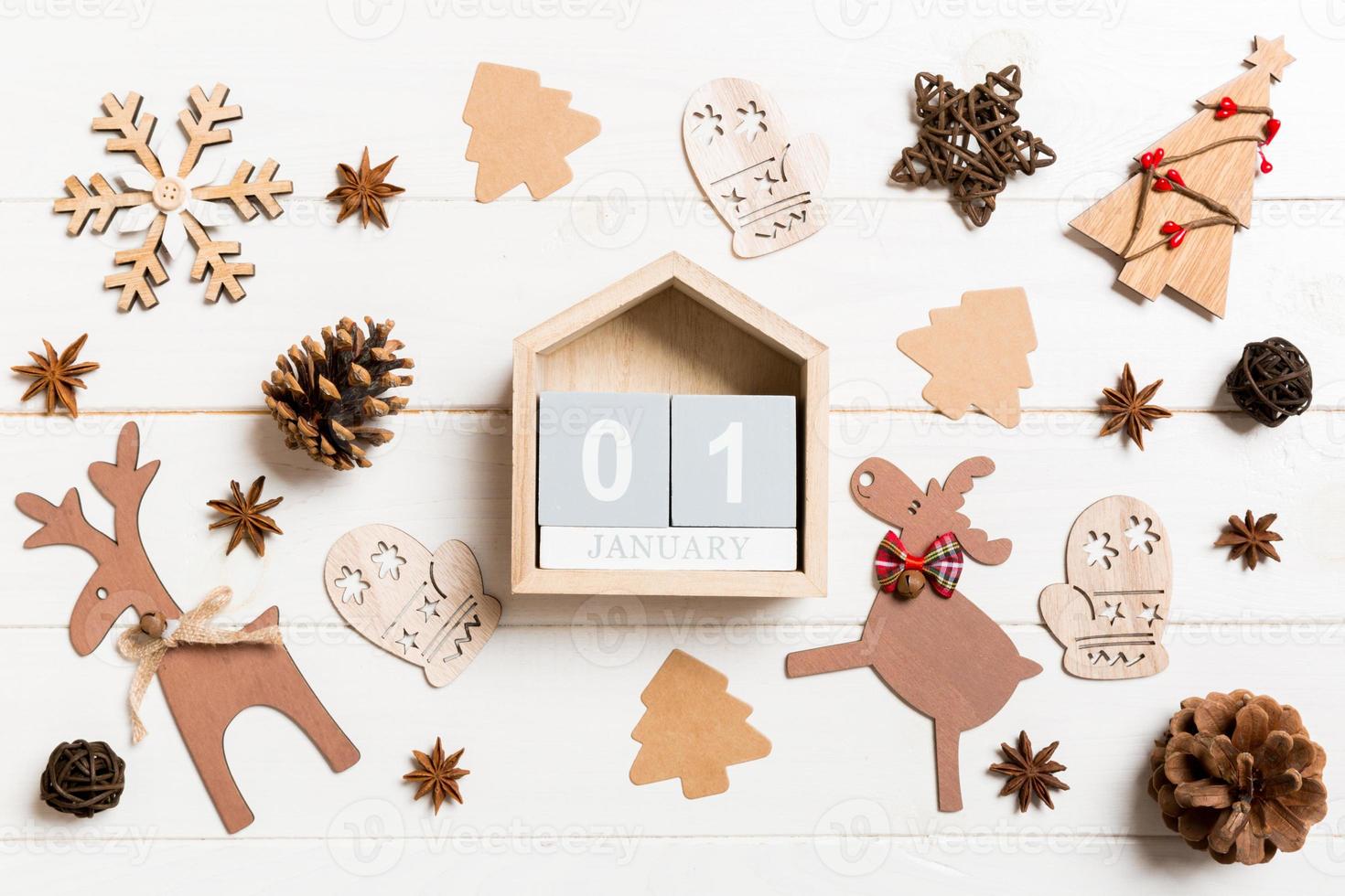 Top view of calendar on Christmas wooden background. The first of January. New Year toys and decorations. Holiday concept photo