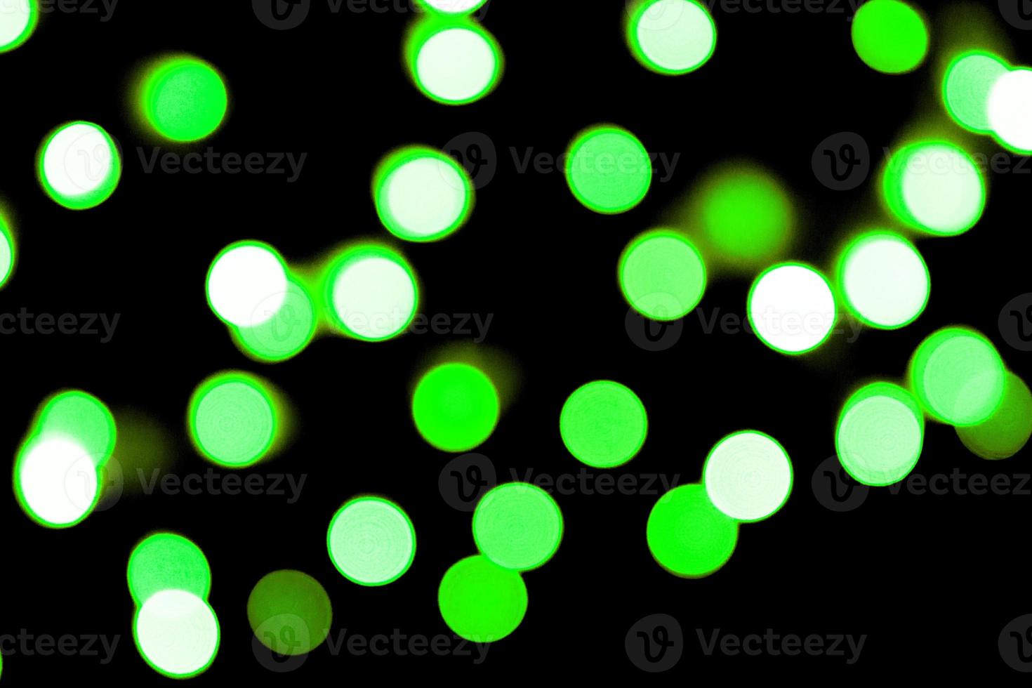 Unfocused abstract colourful bokeh black background. defocused and blurred many round green light photo