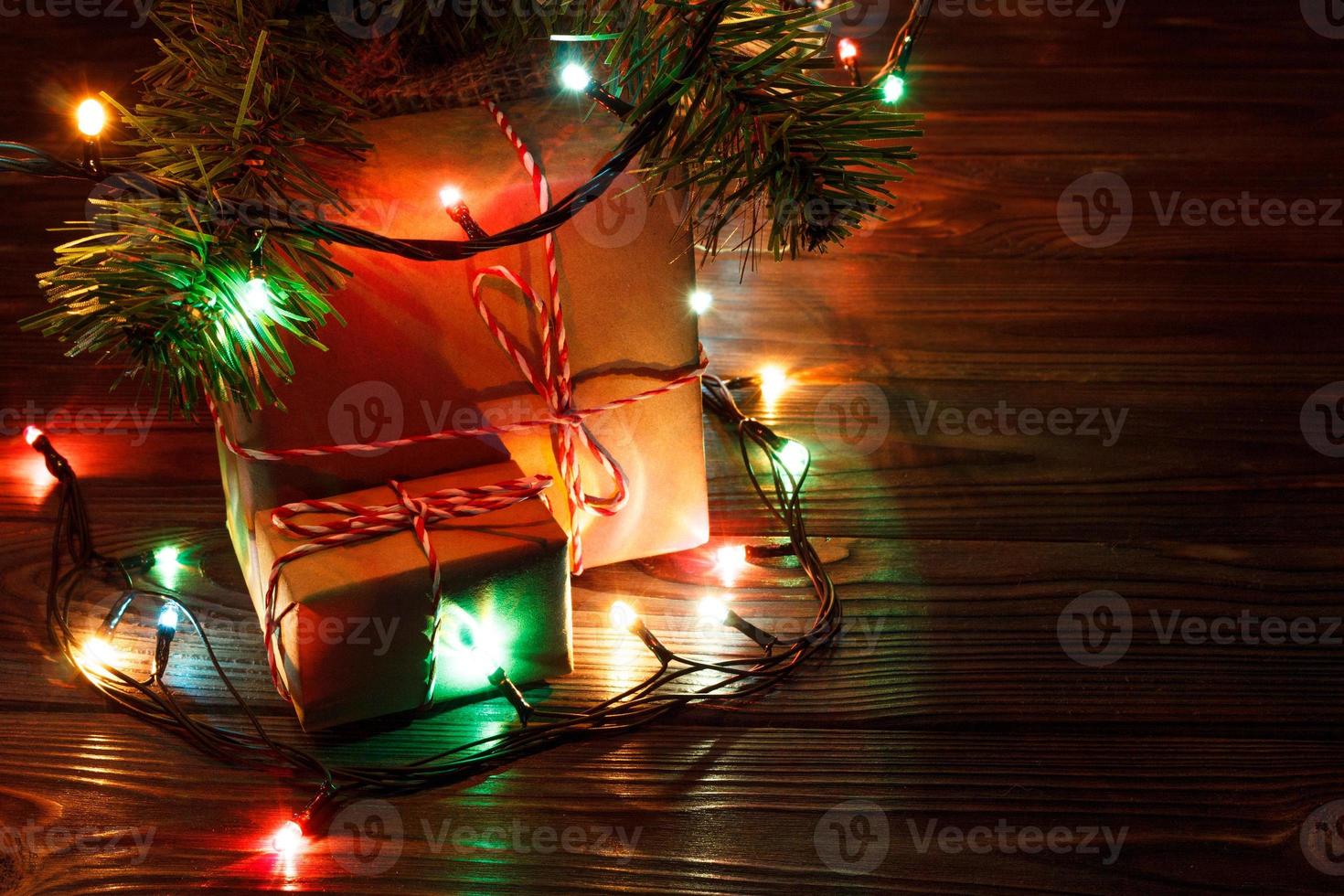pila de cajas de regalo debajo del árbol de navidad al lado de la chimenea en la sala de estar foto