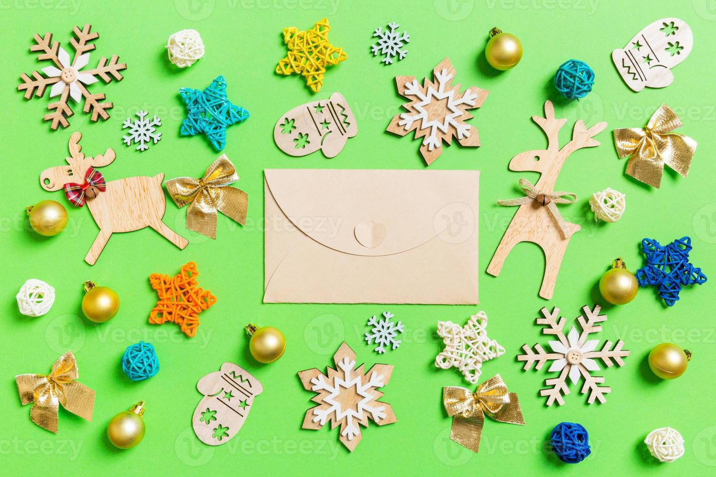 Top view of craft envelope on green background with New Year toys and decorations. Christmas time concept photo