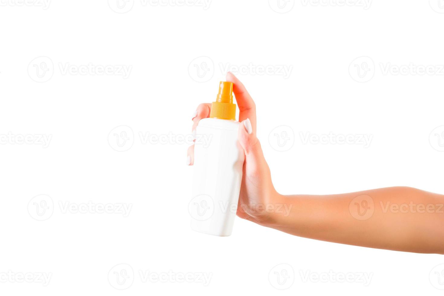 Female hand holding cream bottle of lotion isolated. Girl give cosmetic products on white background photo