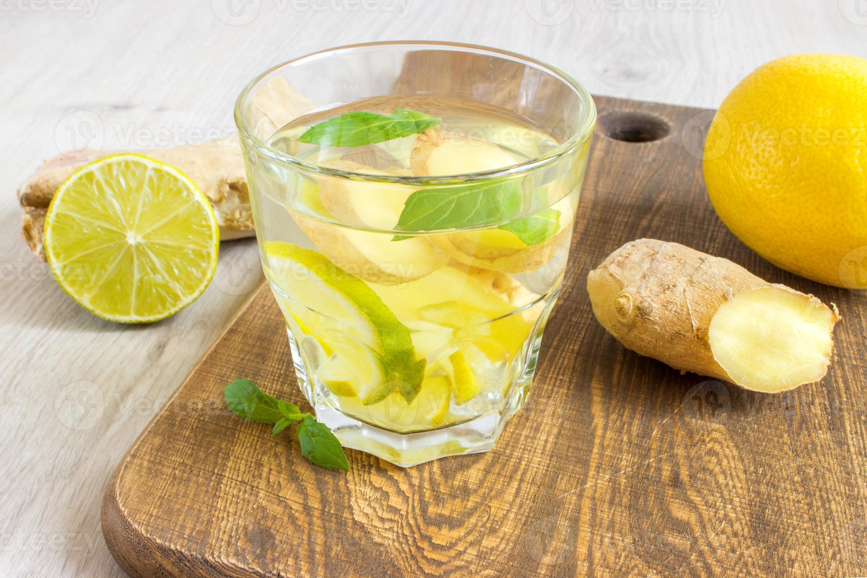 Ginger ale soda with lemon, mint, ginger and ice over rustic wooden