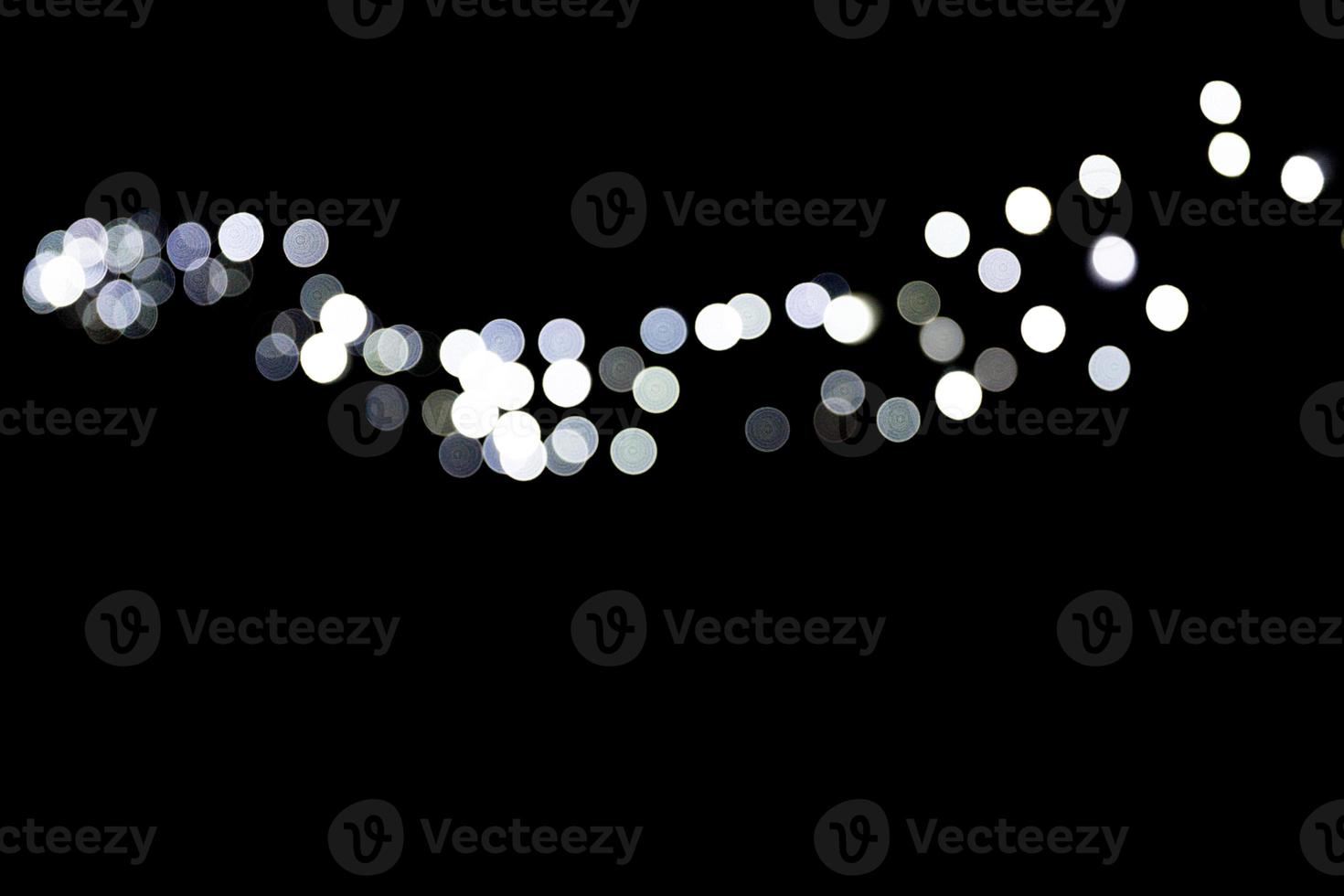 Abstract bokeh of white city lights on black background. defocused and blurred many round light photo