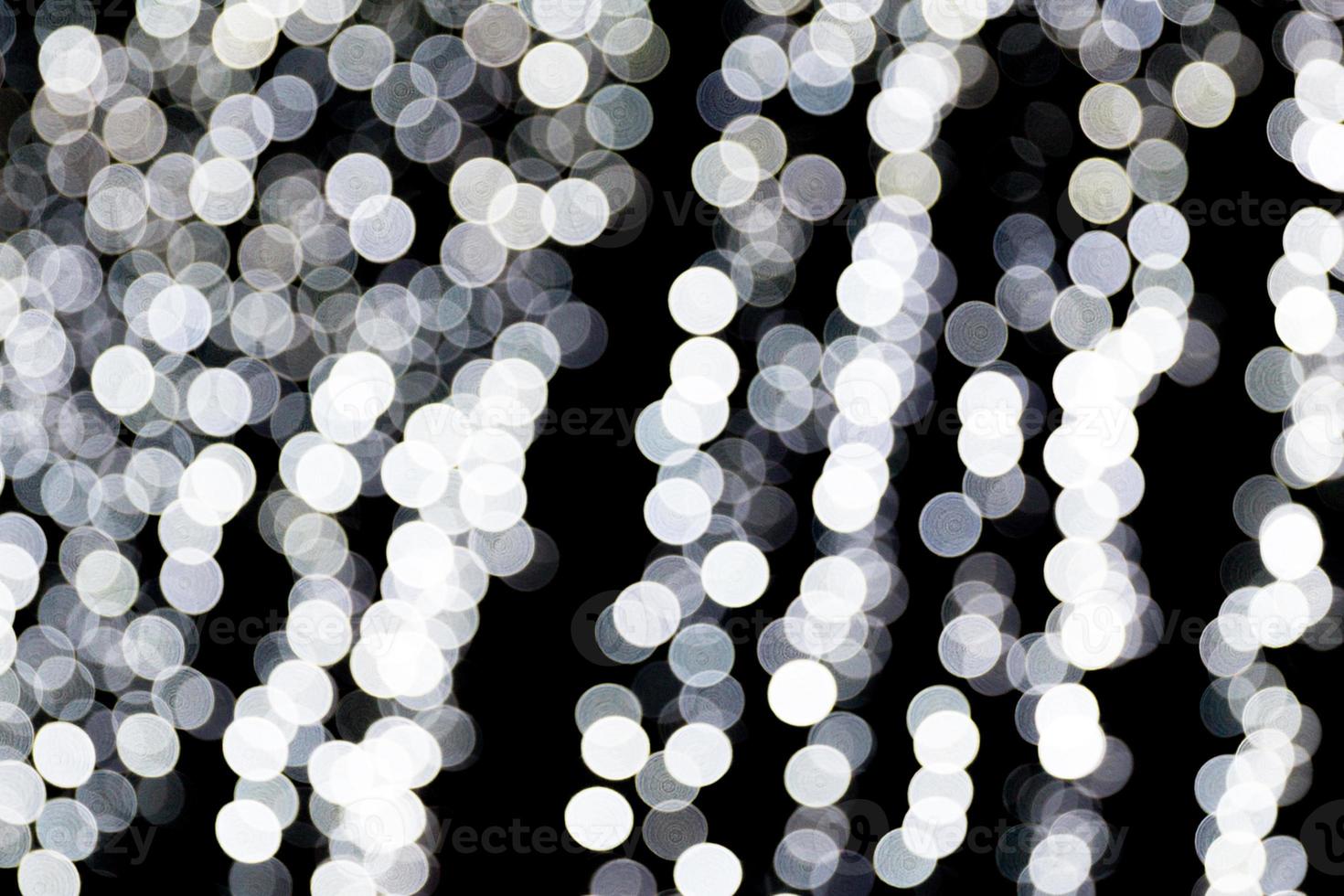 Abstract bokeh of white city lights on black background. defocused and blurred many round light photo