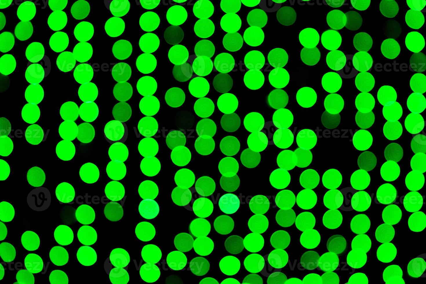 Bokeh verde abstracto desenfocado sobre fondo negro. desenfocado y borroso muchas luces redondas foto