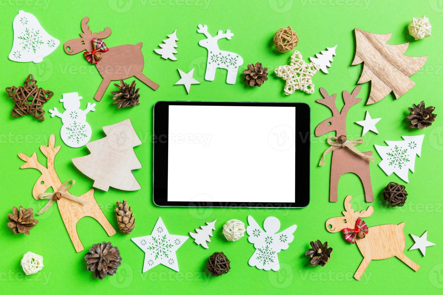 fondo verde de navidad con juguetes y decoraciones navideñas. vista superior de la tableta digital. feliz año nuevo concepto foto