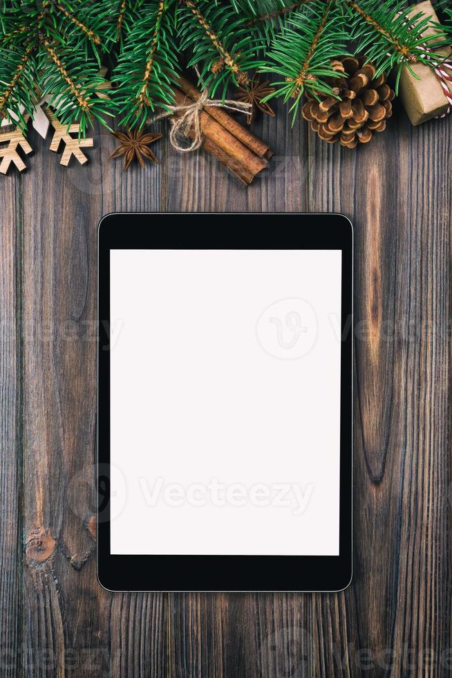 Digital tablet mock up with rustic Christmas vintage, toned wood background decorations for app presentation. top view with copy space photo
