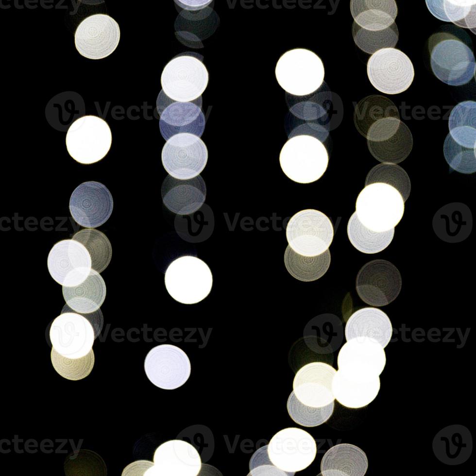 Abstract light bokeh as background defocused and blurred many round light on black background photo