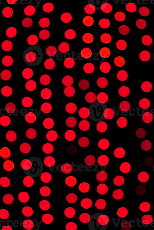 Unfocused abstract red bokeh on black background. defocused and blurred many round light photo