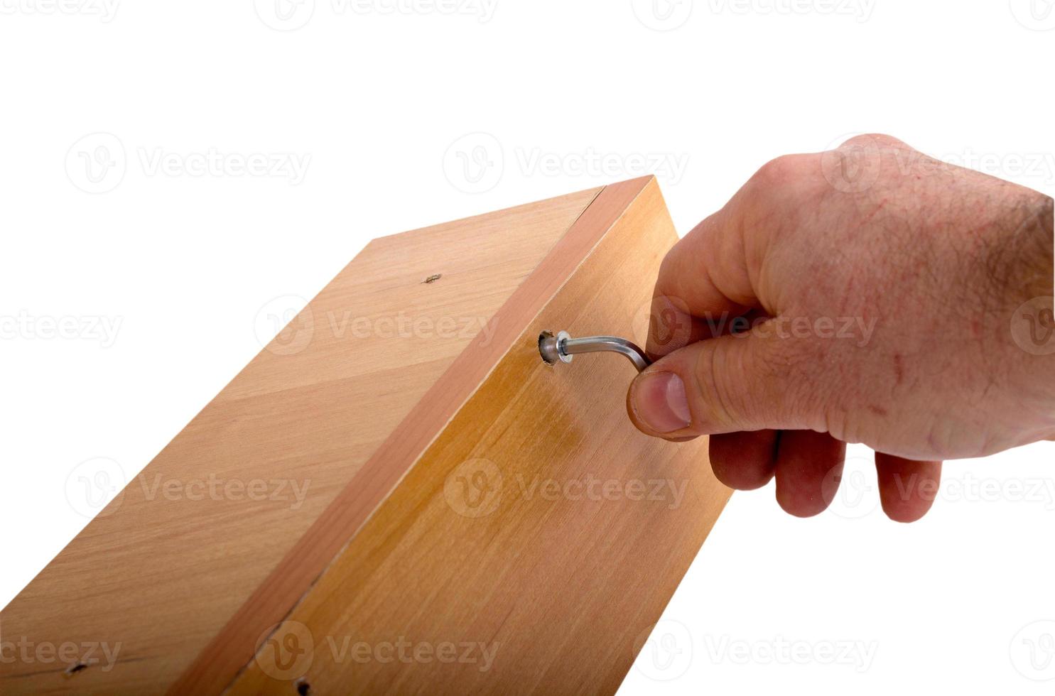 Self-assembly furniture, hand with an Allen key photo