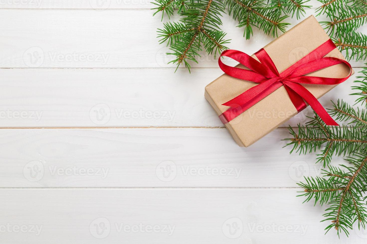 Christmas Background Christmas gift with fir branches on wooden white background with copy space Flat lay, top view photo