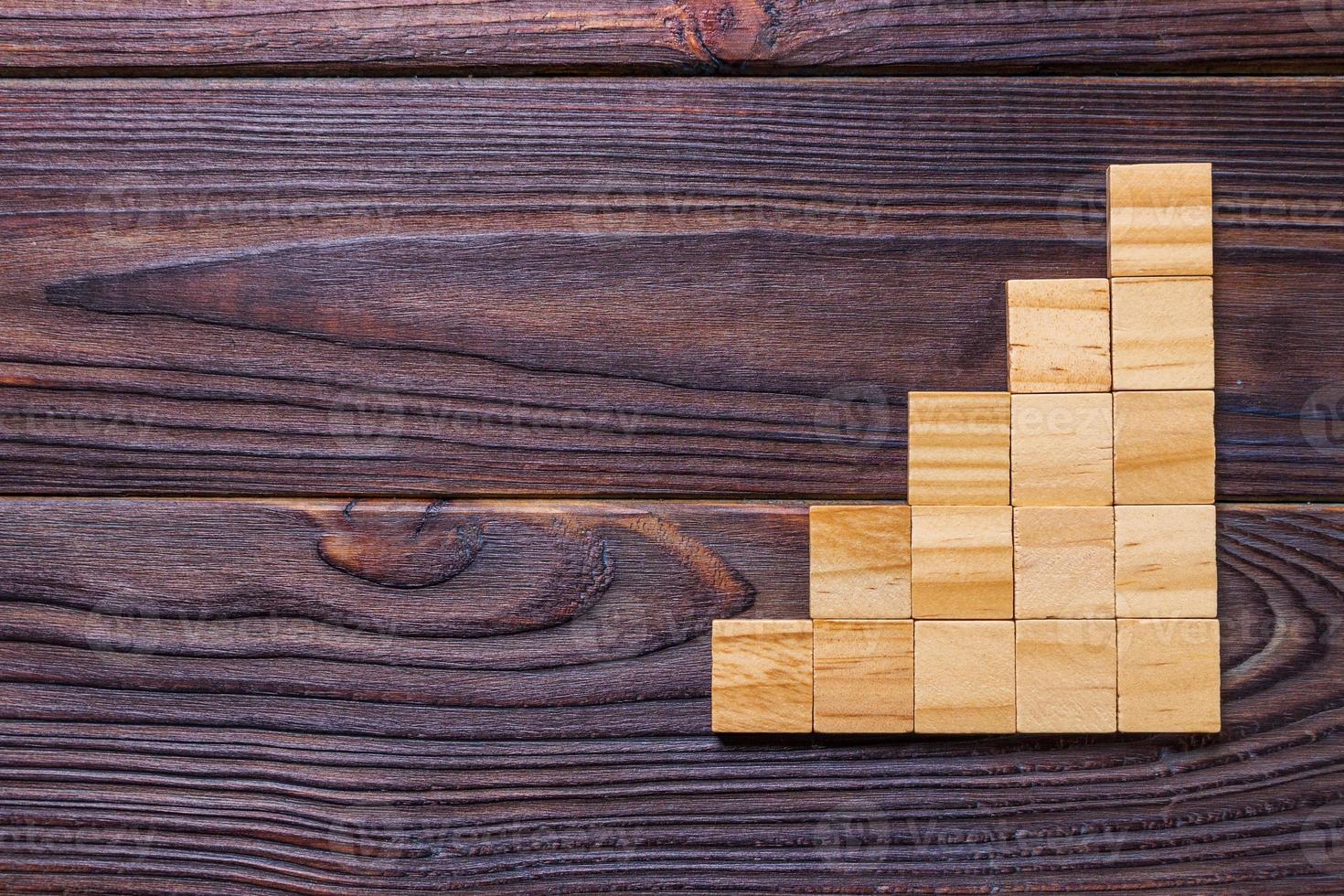 A wooden blocks cube over black wooden textured background with copy space for add word text title. Concept or conceptual Wood block stair or five steps. Cubic photo