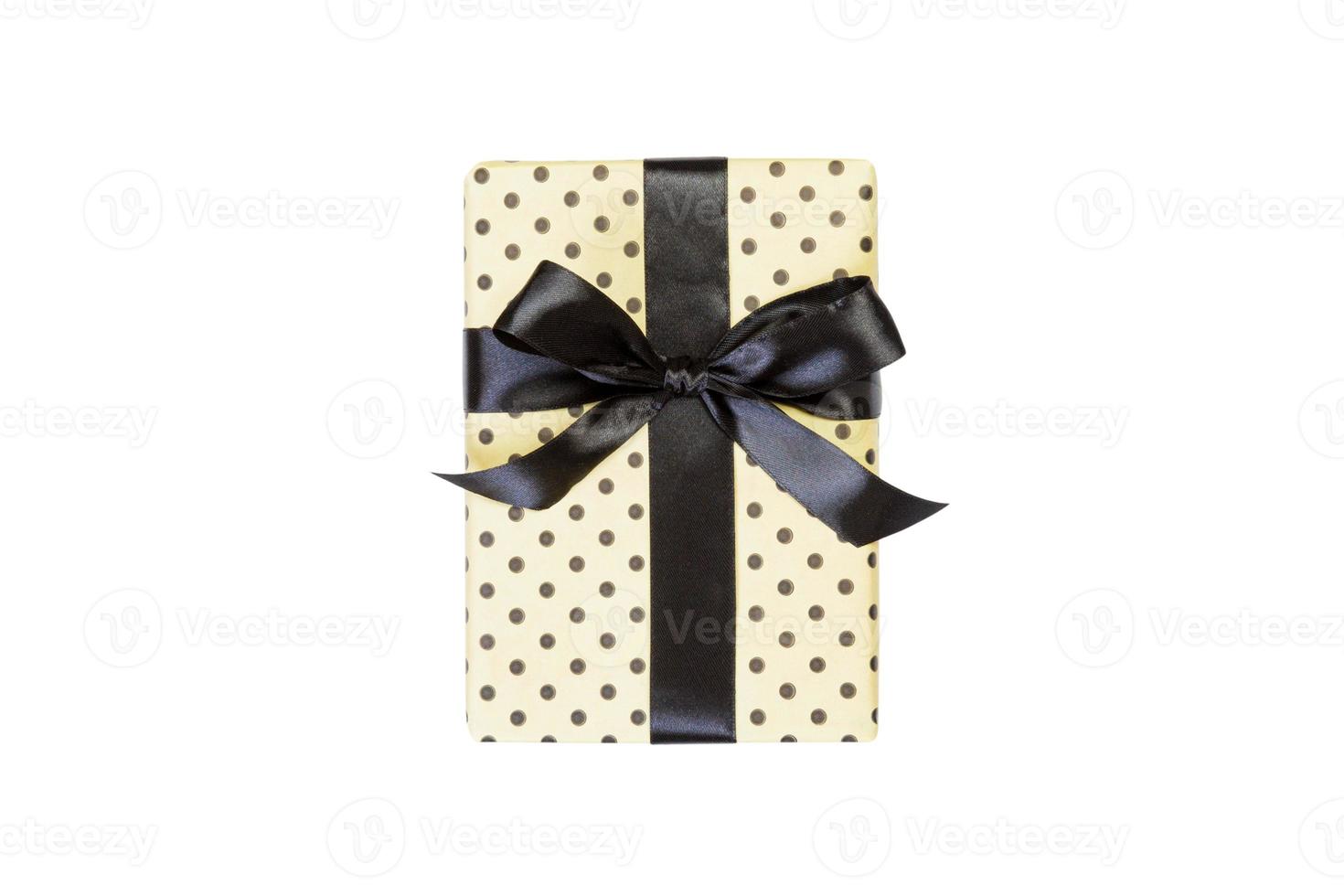 Christmas or other holiday handmade present in yellow paper with black ribbon. Isolated on white background, top view. thanksgiving Gift box concept photo