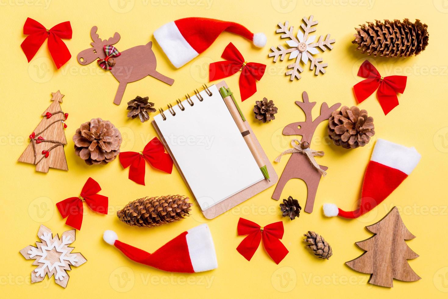 Christmas yellow background with holiday toys and decorations. Top view of notebook. Happy New Year concept photo